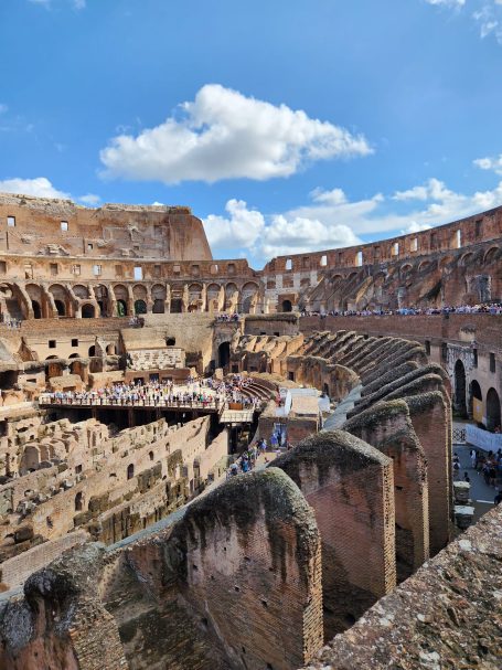 Colosseum Rome Italy Interior view of the Colosseum showing stone seating and a blue sky with clouds.
